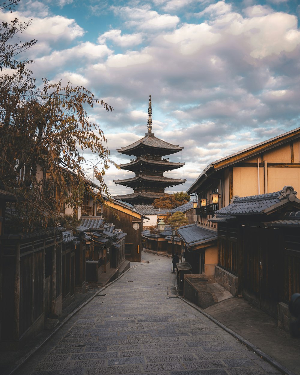 a narrow street with a pagoda in the background