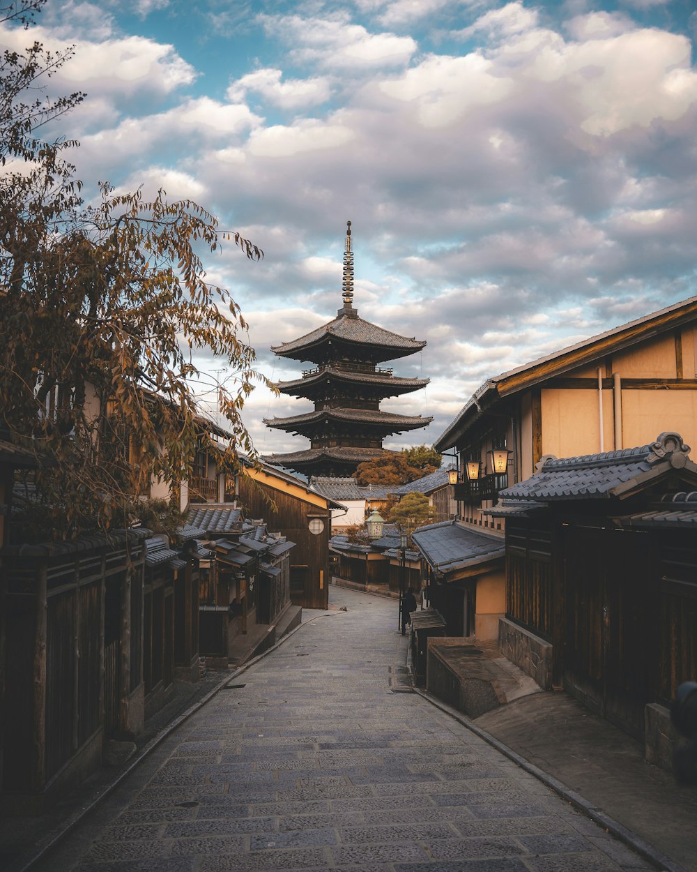 Una calle estrecha con una pagoda al fondo