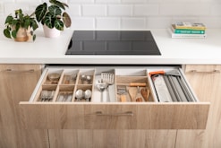 a kitchen drawer filled with utensils and a potted plant