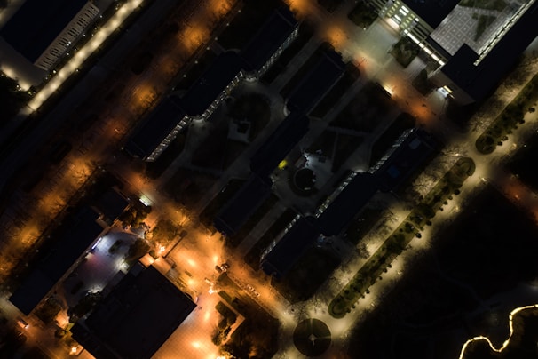 A night view of a Jewar Airport approved project showing illuminated buildings and safe, well-maintained streets.