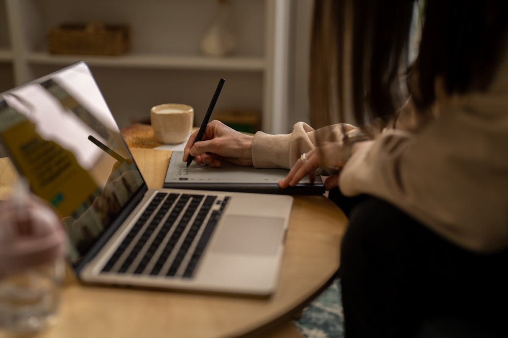 uma pessoa sentada em uma mesa com um laptop