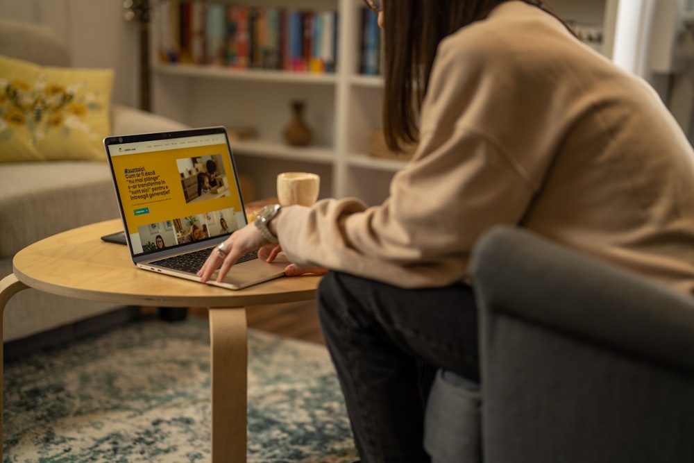 a woman sitting in a chair using a laptop computer