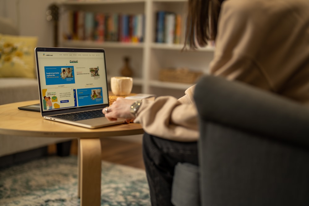 a woman sitting in a chair using a laptop computer