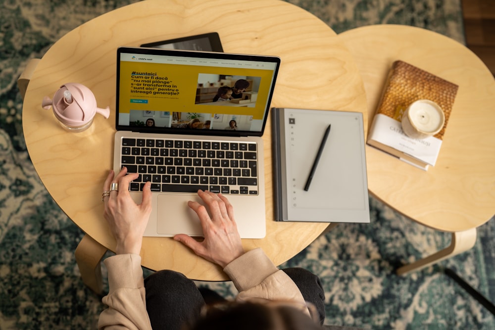 a person sitting at a table with a laptop