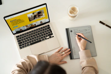 Student using a tablet, highlighting study notes with focused expression.