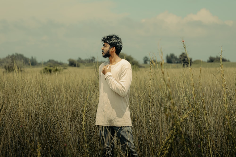 a man standing in a field of tall grass