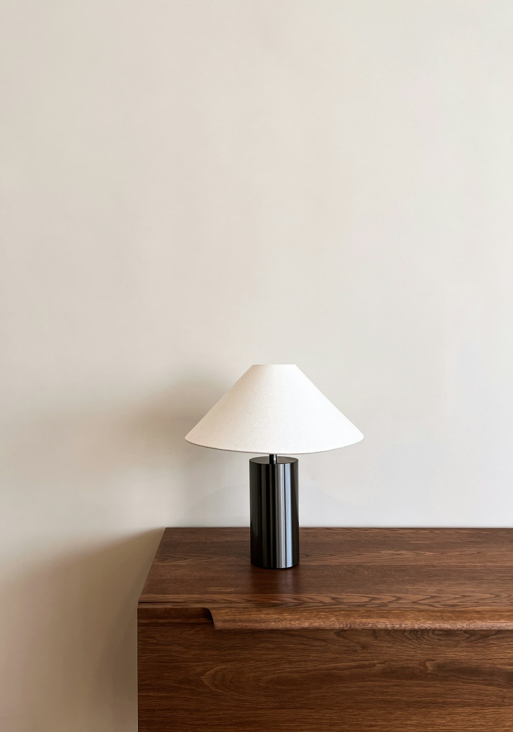 a lamp sitting on top of a wooden dresser