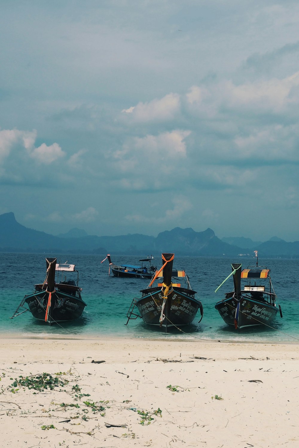 a group of boats sitting on top of a sandy beach