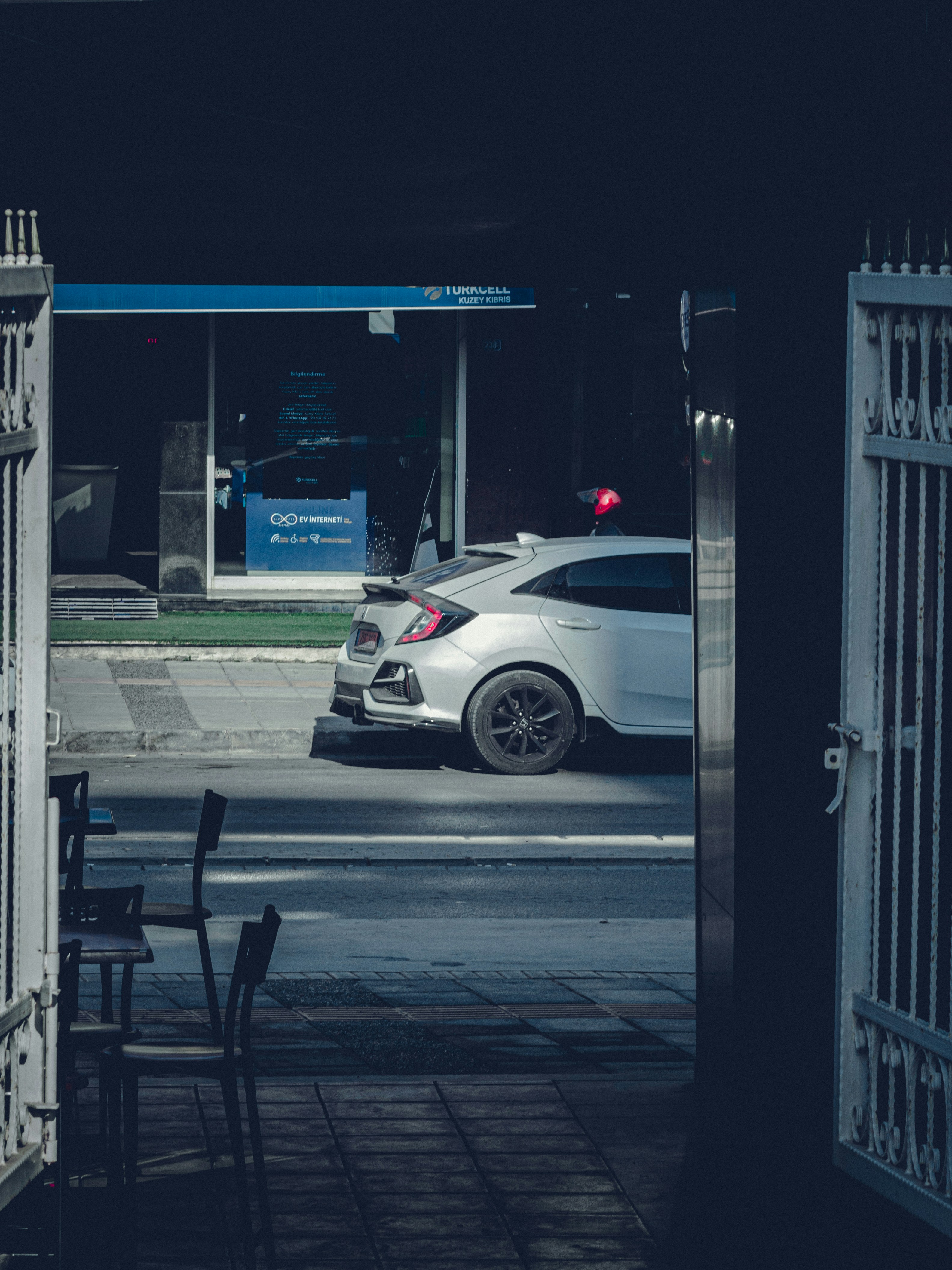 A white car driving down a street at night