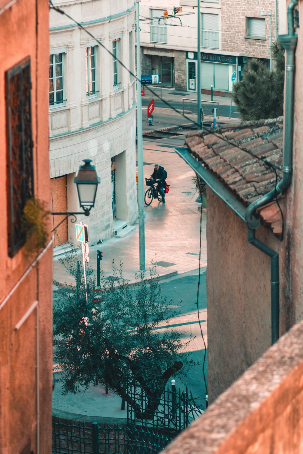 a man riding a bike down a street next to tall buildings