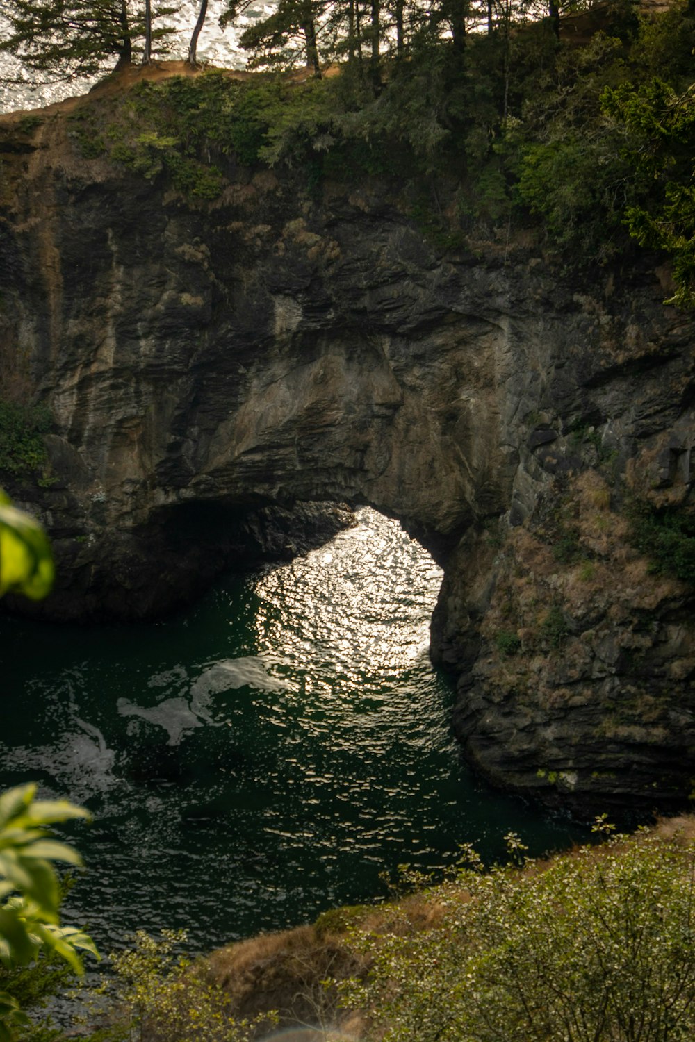 a large rock arch over a body of water