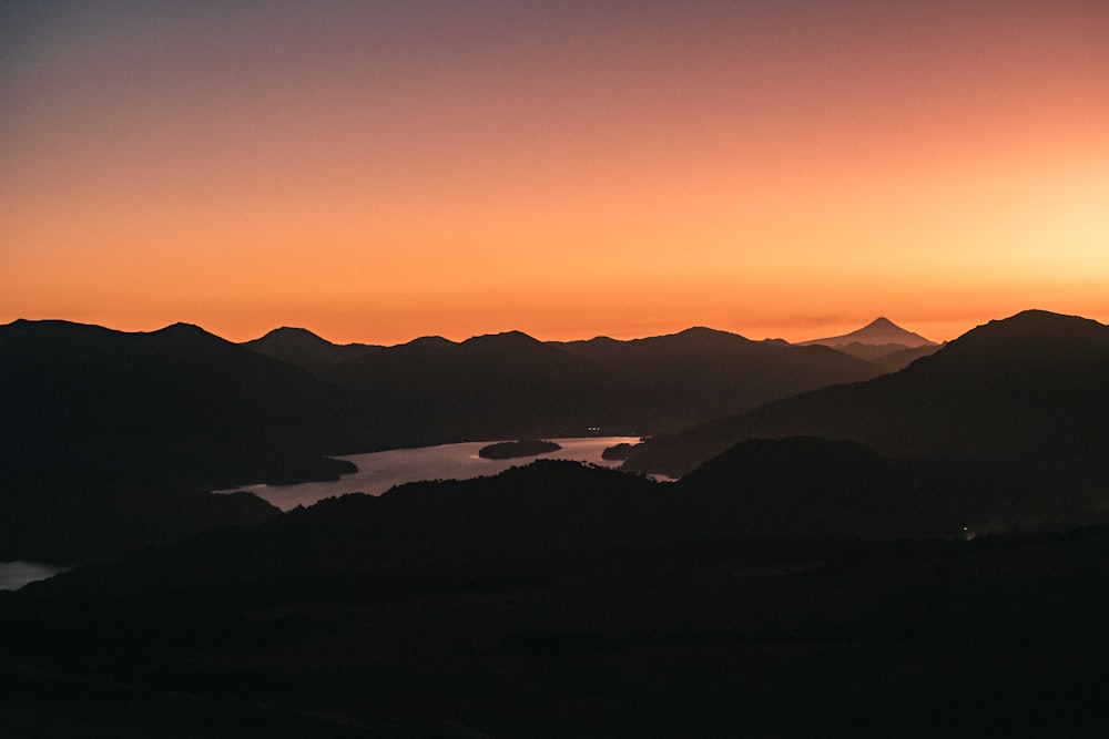 the sun is setting over a mountain range