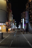 Nighttime exterior of a Seven Electronics store glowing with urban neon lights and bold signage.