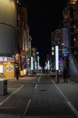 Nighttime exterior of a Seven Electronics store glowing with urban neon lights and bold signage.
