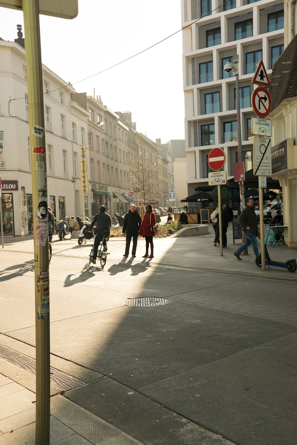 a group of people walking down a street next to tall buildings