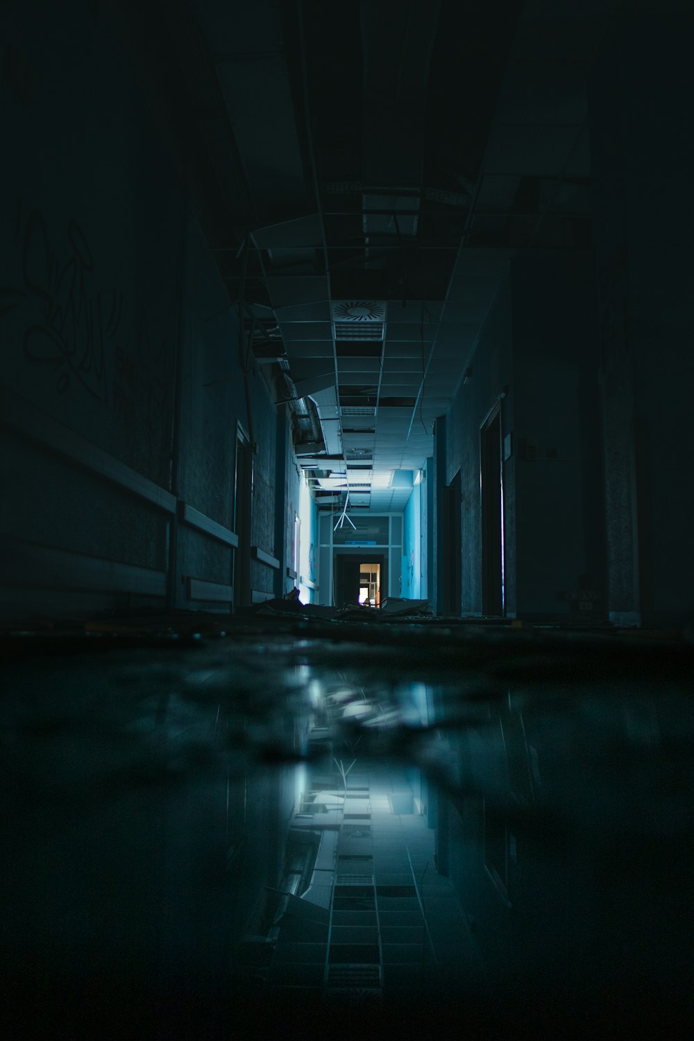 a dark hallway with a light at the end of it