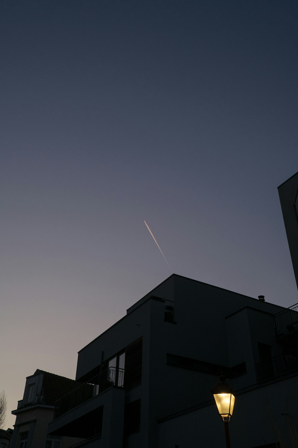 Ein Flugzeug fliegt am Himmel über einem Gebäude