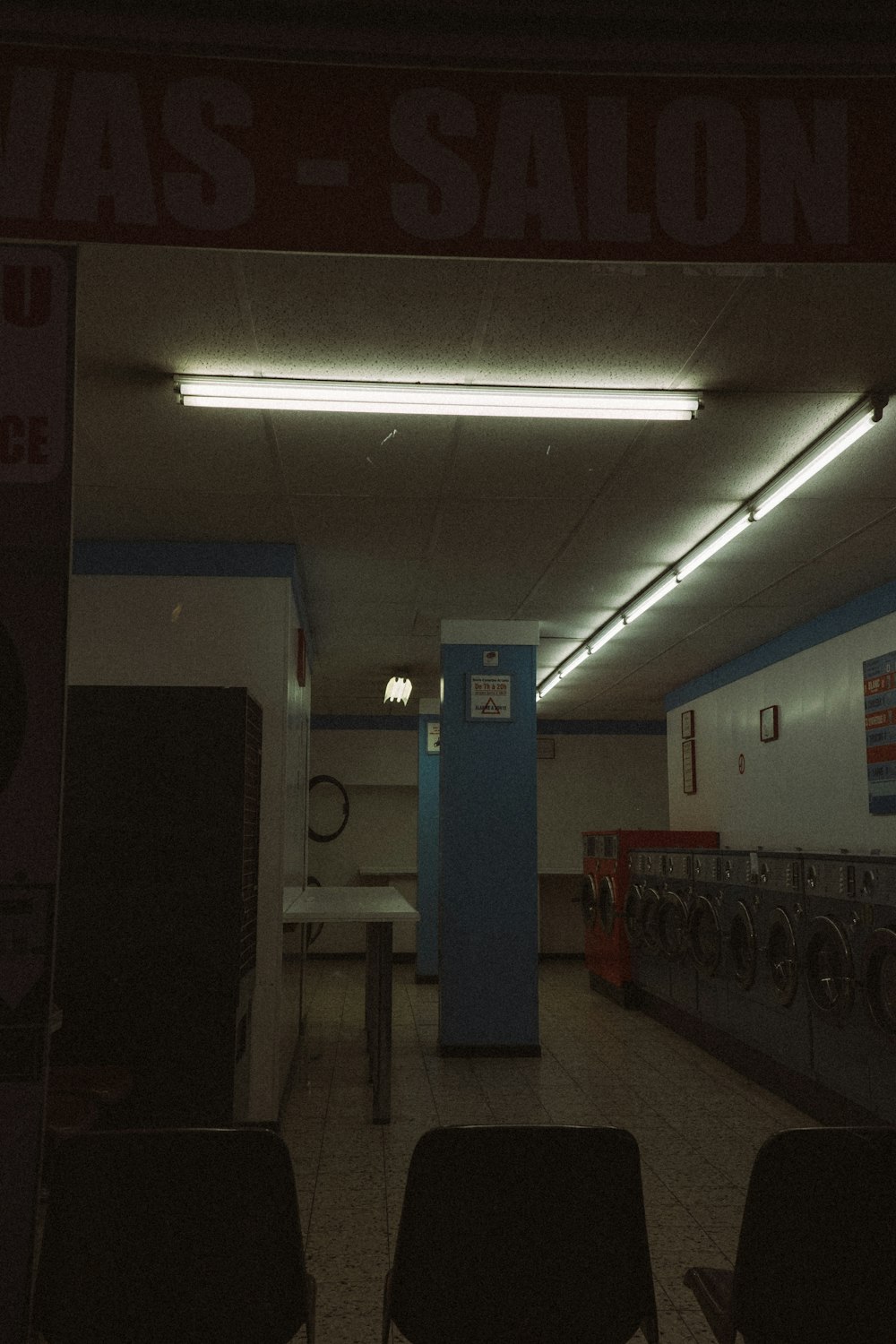 a washroom with a lot of machines and chairs