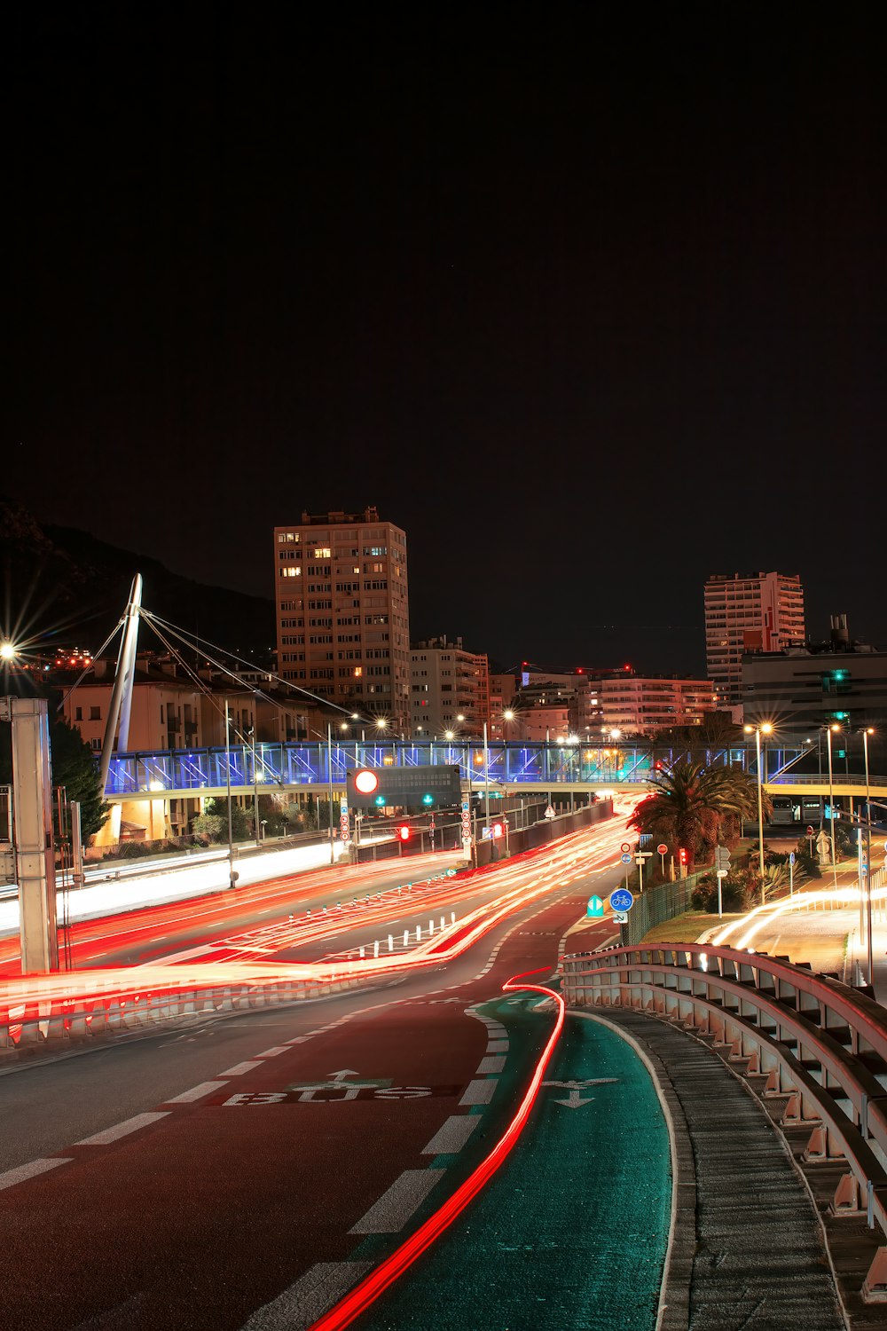 a city street at night with cars passing by