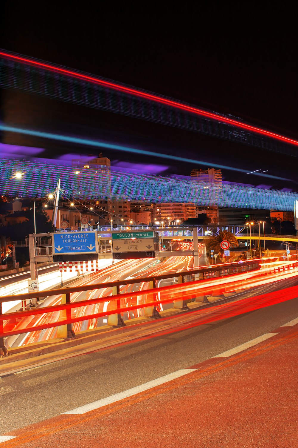 a long exposure photo of a highway at night