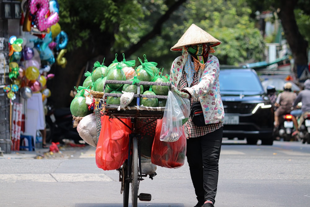 a woman pushing a cart filled with lots of produce