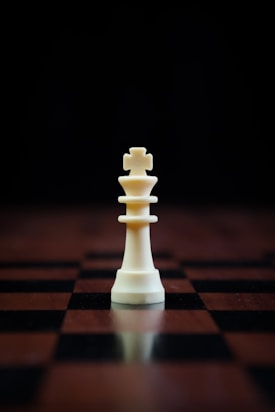 a white chess piece sitting on top of a chess board