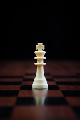 a white chess piece sitting on top of a chess board