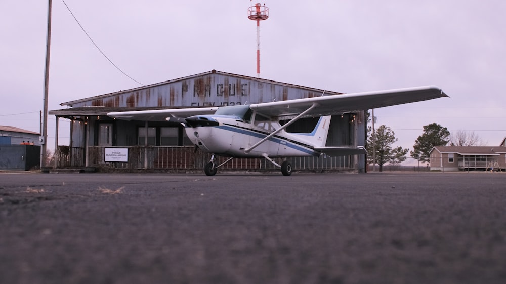um pequeno avião estacionado em frente a um edifício