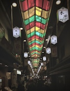 A colorful photo of a bustling Japanese street market with lanterns and tourists