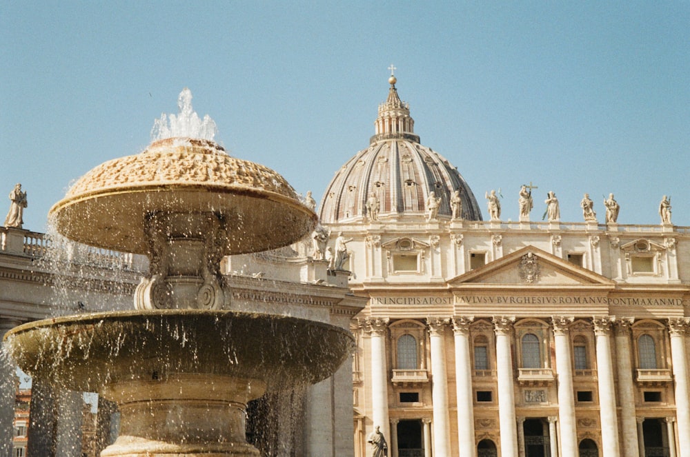 a fountain in front of a building with a dome in the background