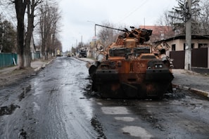 A fierce vehicle combat scene with armored trucks exchanging fire on a muddy, dark blue shoreline.