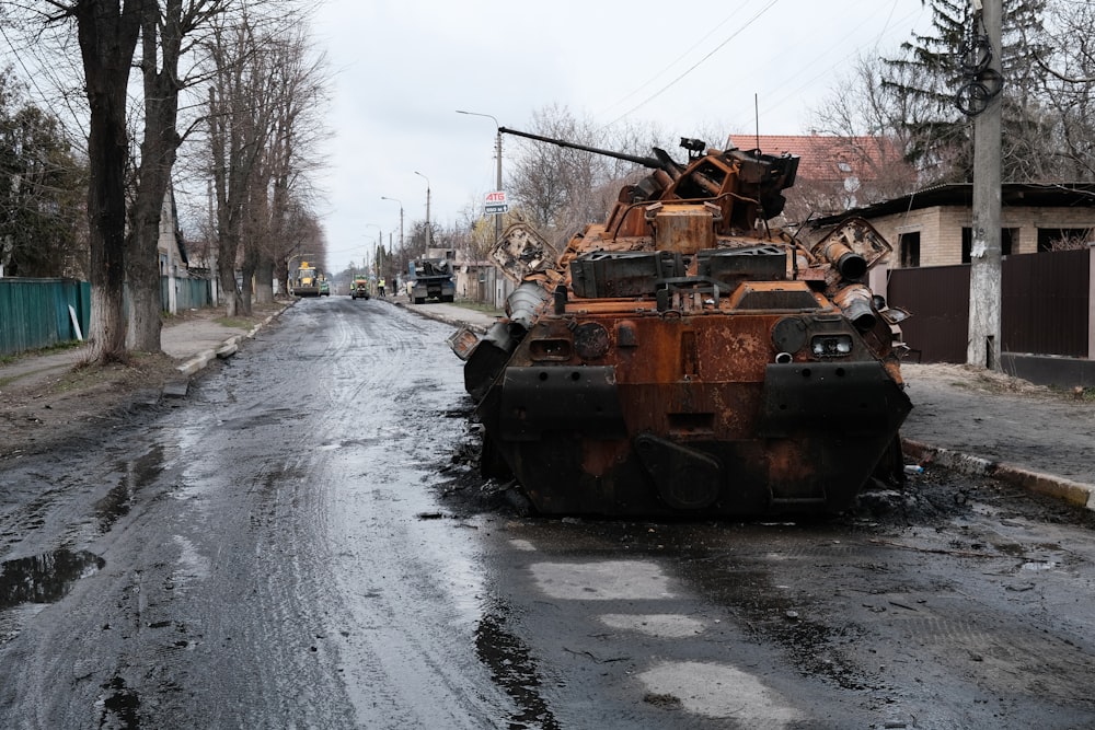 a large rusted out tank sitting on the side of a road