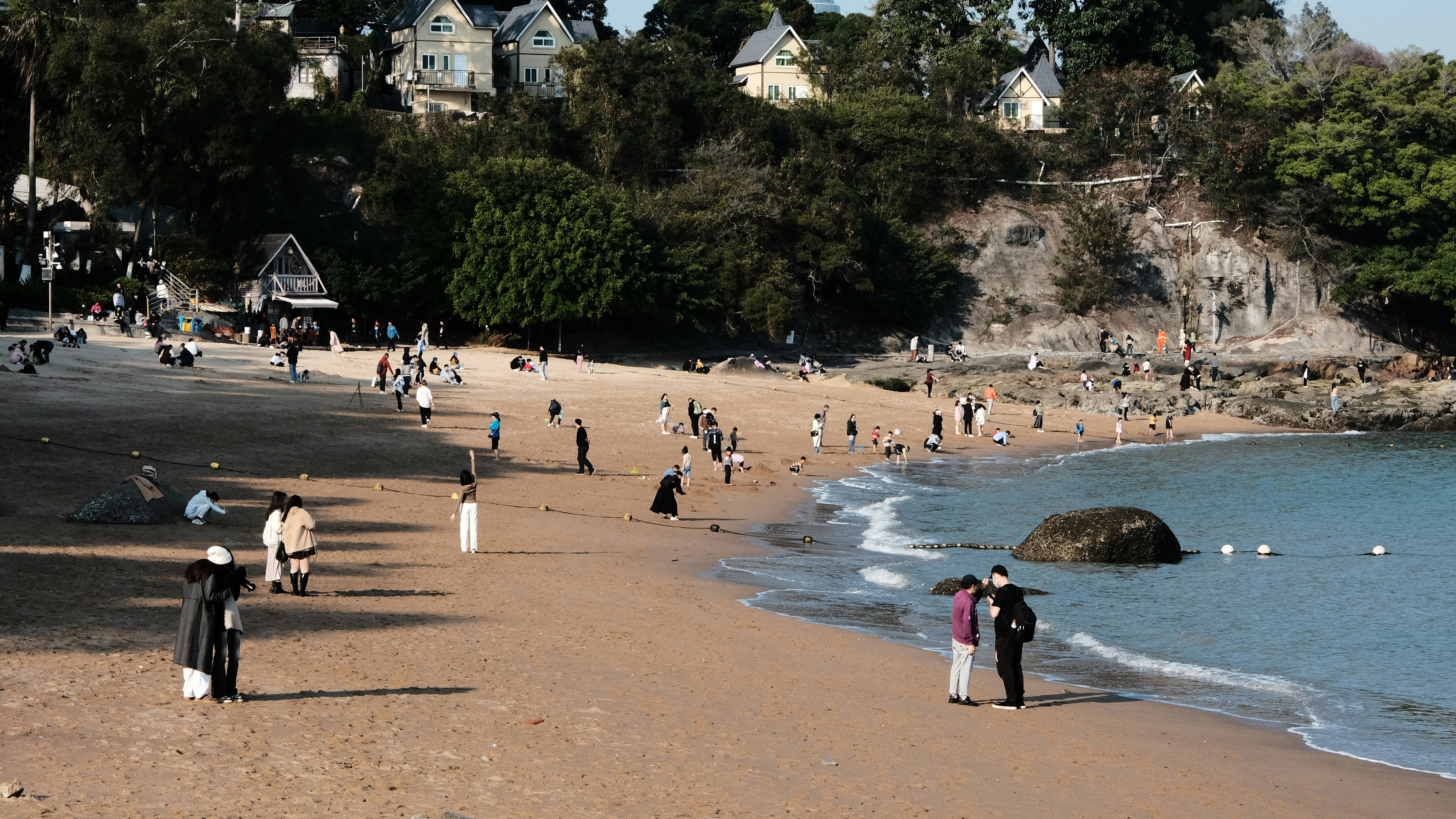 a group of people standing on top of a sandy beach