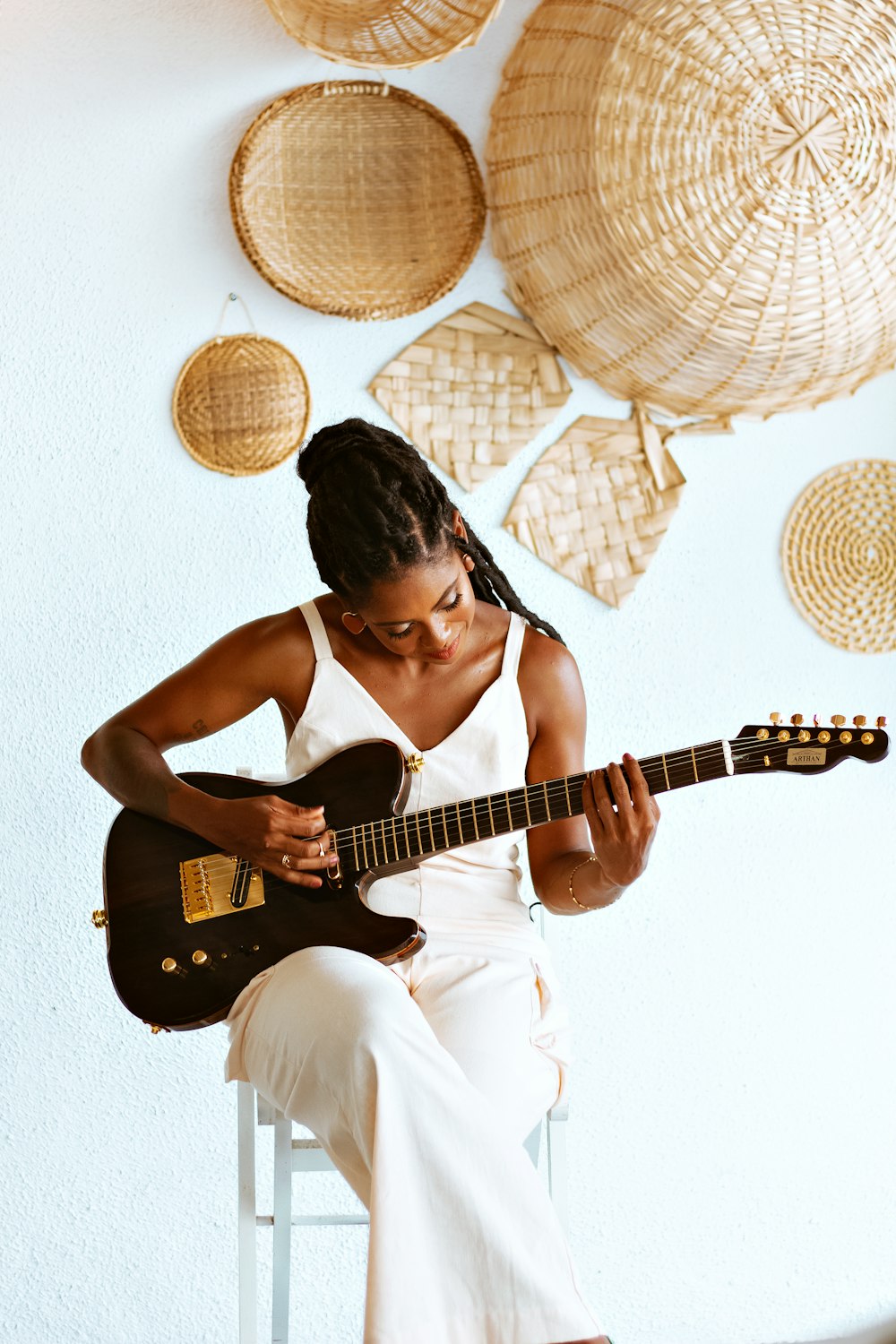 a woman sitting on a chair playing a guitar