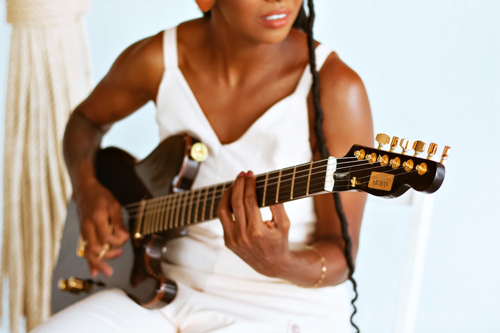 a woman sitting down playing a guitar