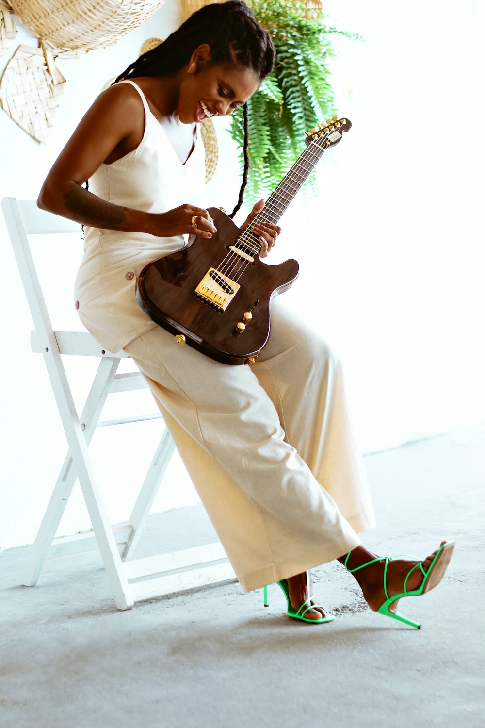 a woman sitting on a chair holding a guitar