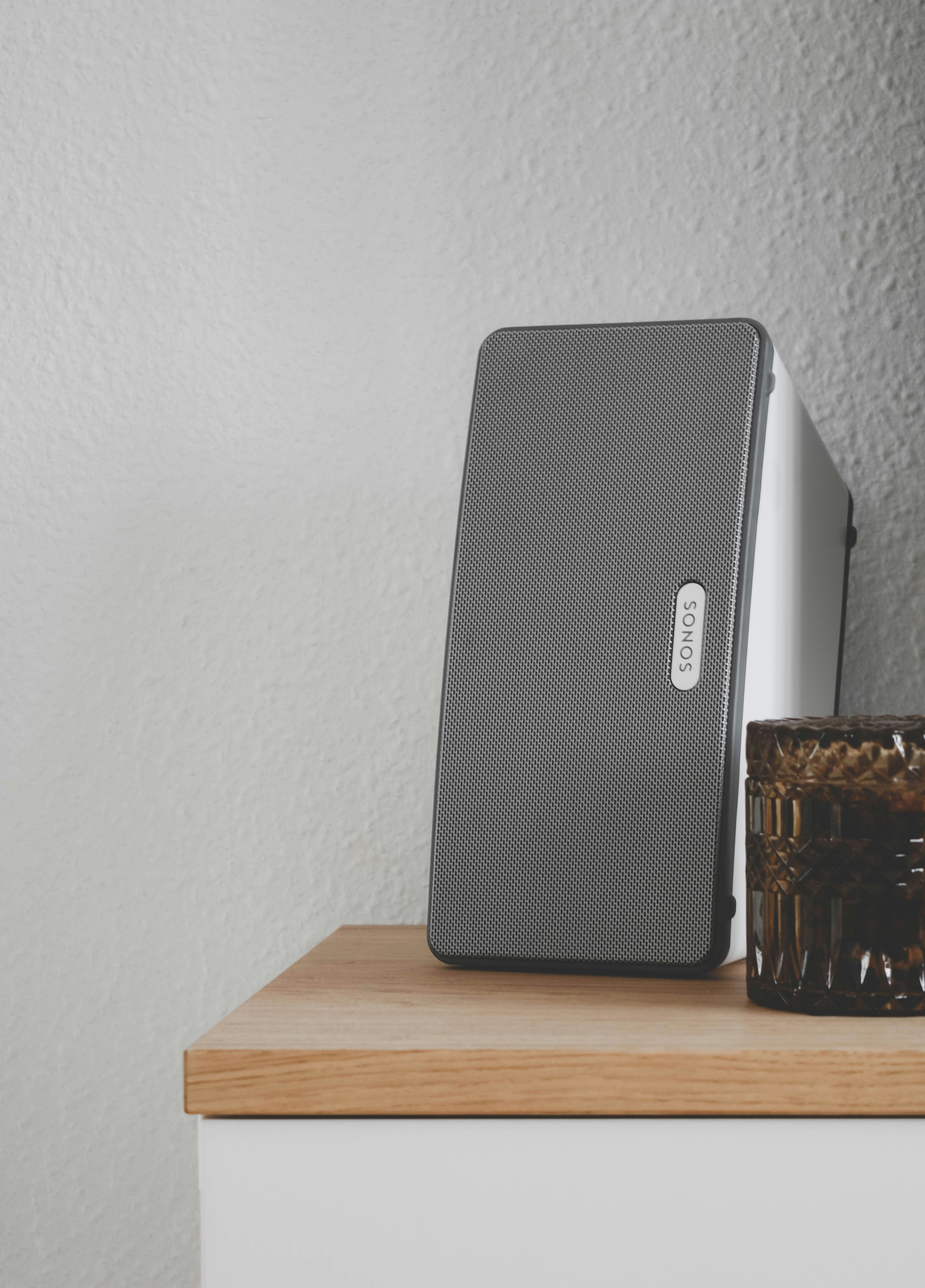 a speaker sitting on top of a table next to a glass