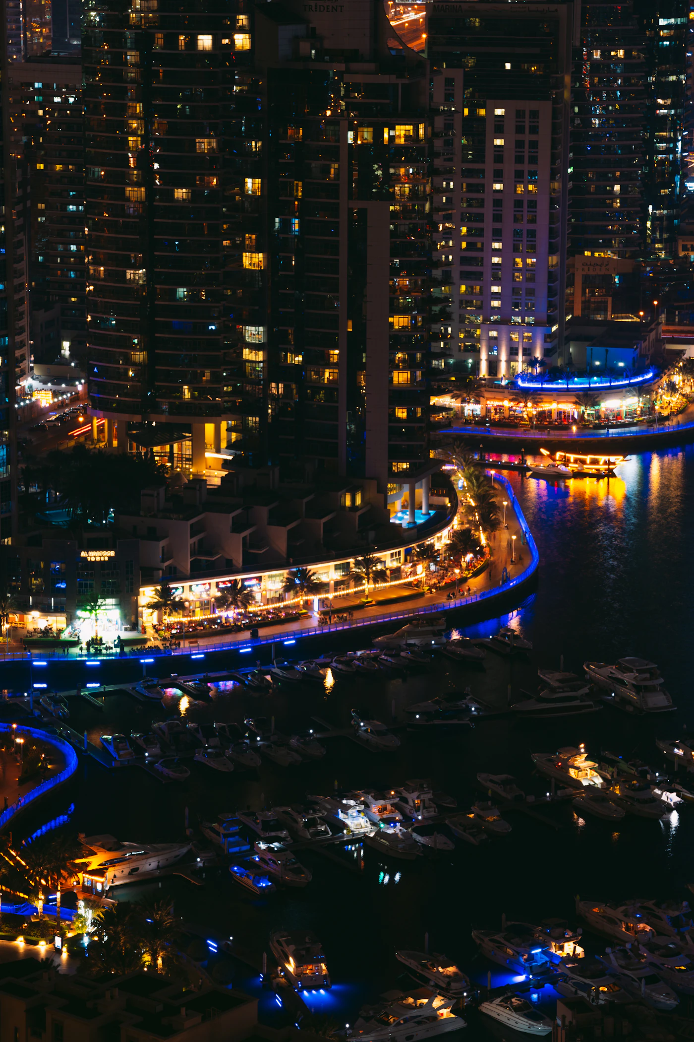 Beleuchtete Hochhäuser und Boote am Marina Walk bei Nacht