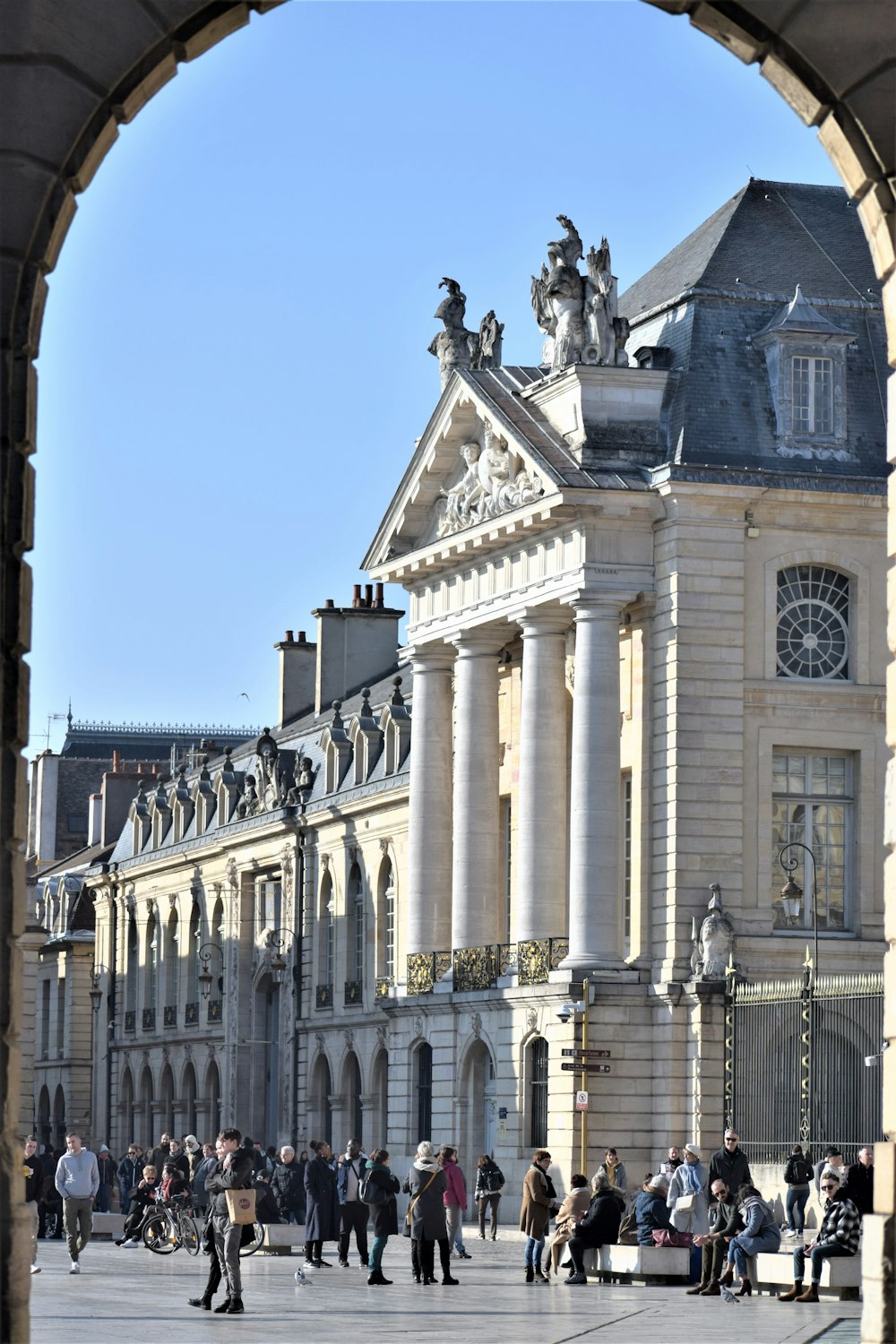 un groupe de personnes marchant devant un grand bâtiment