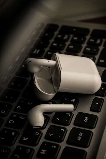 Stylish Baseus wireless earbuds resting on a modern desk with subtle yellow accents