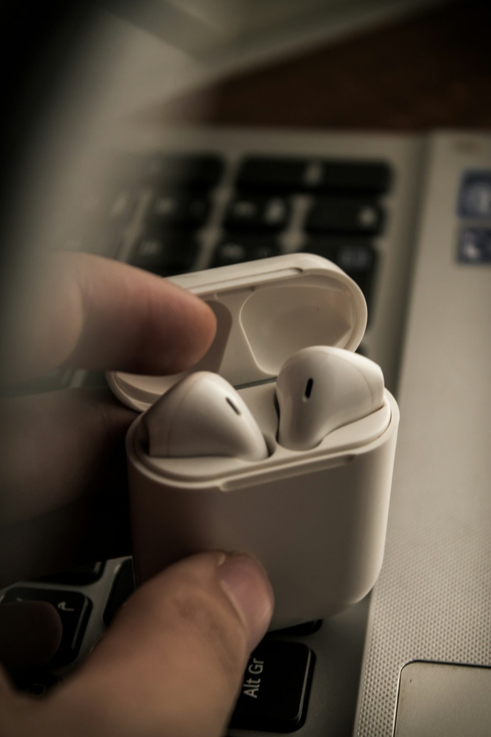 a person is holding a pair of ear buds