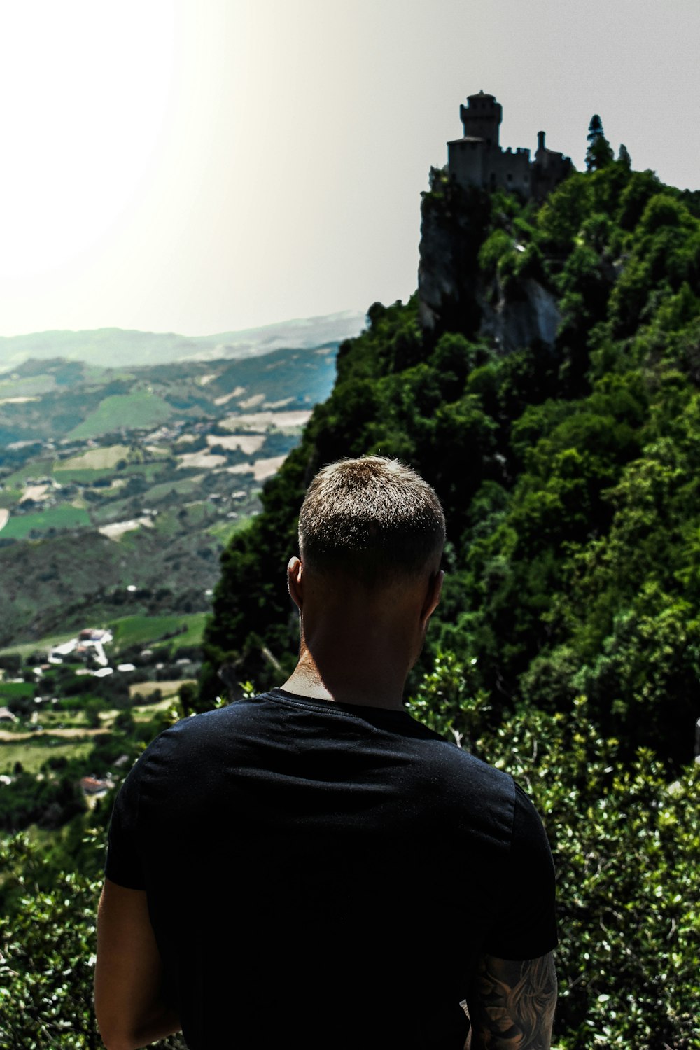 a man sitting on a bench looking at a scenic view