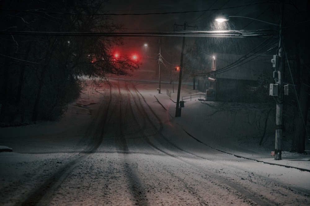 a red traffic light sitting on the side of a snow covered road