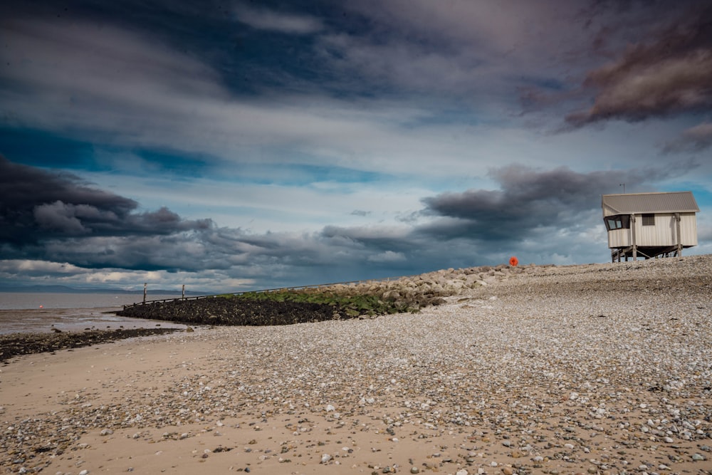 a house sitting on top of a sandy beach