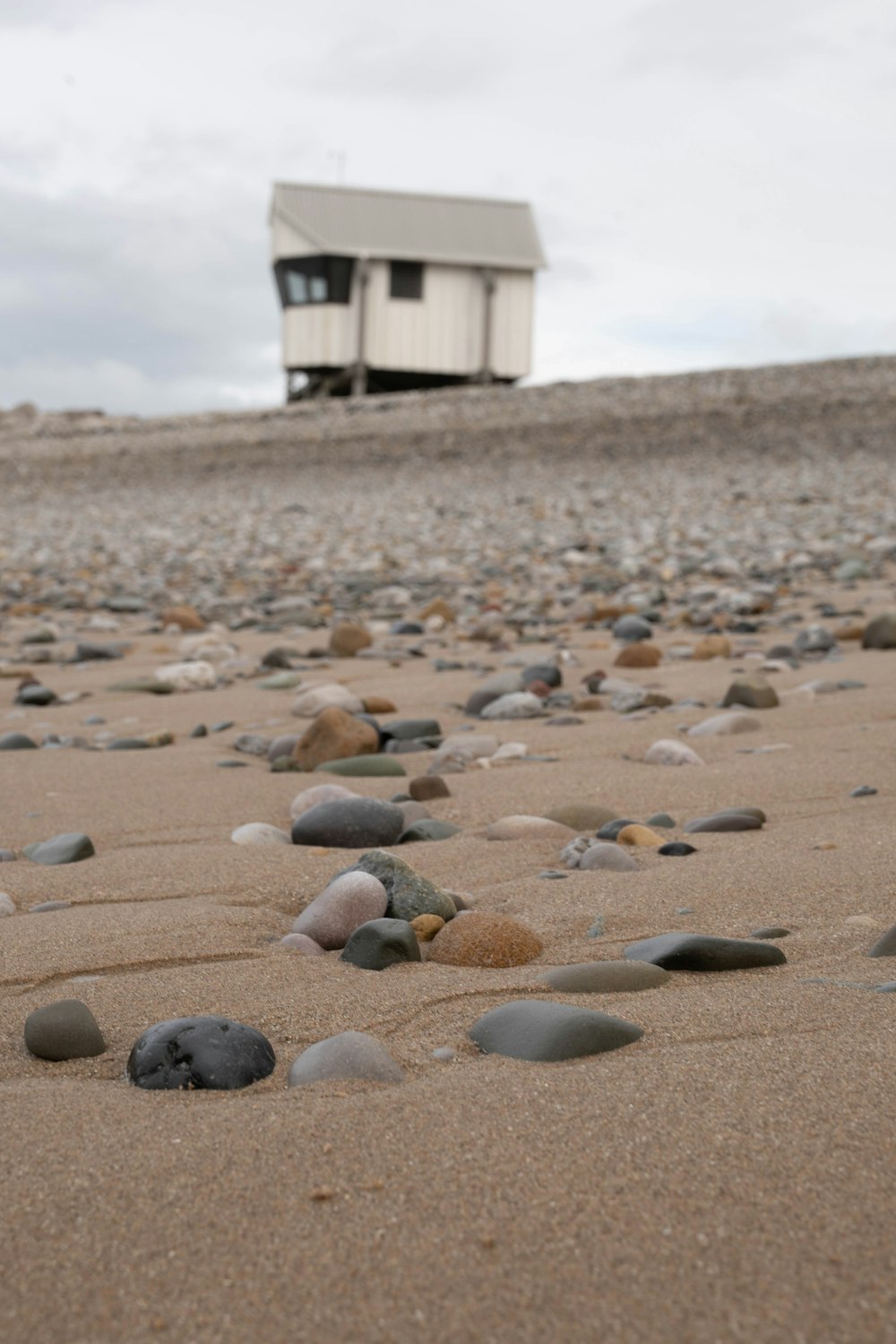 a house sitting on top of a sandy beach