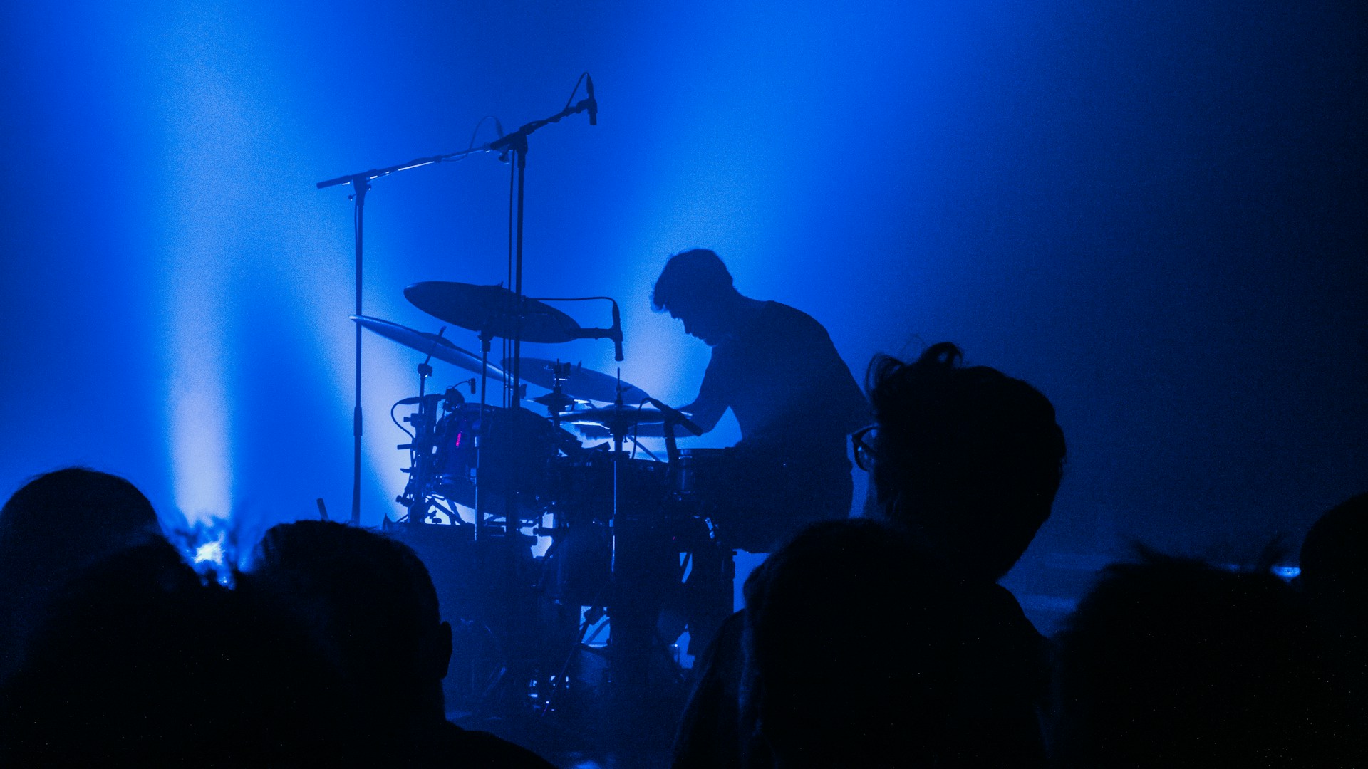 a man playing drums in front of a crowd of people