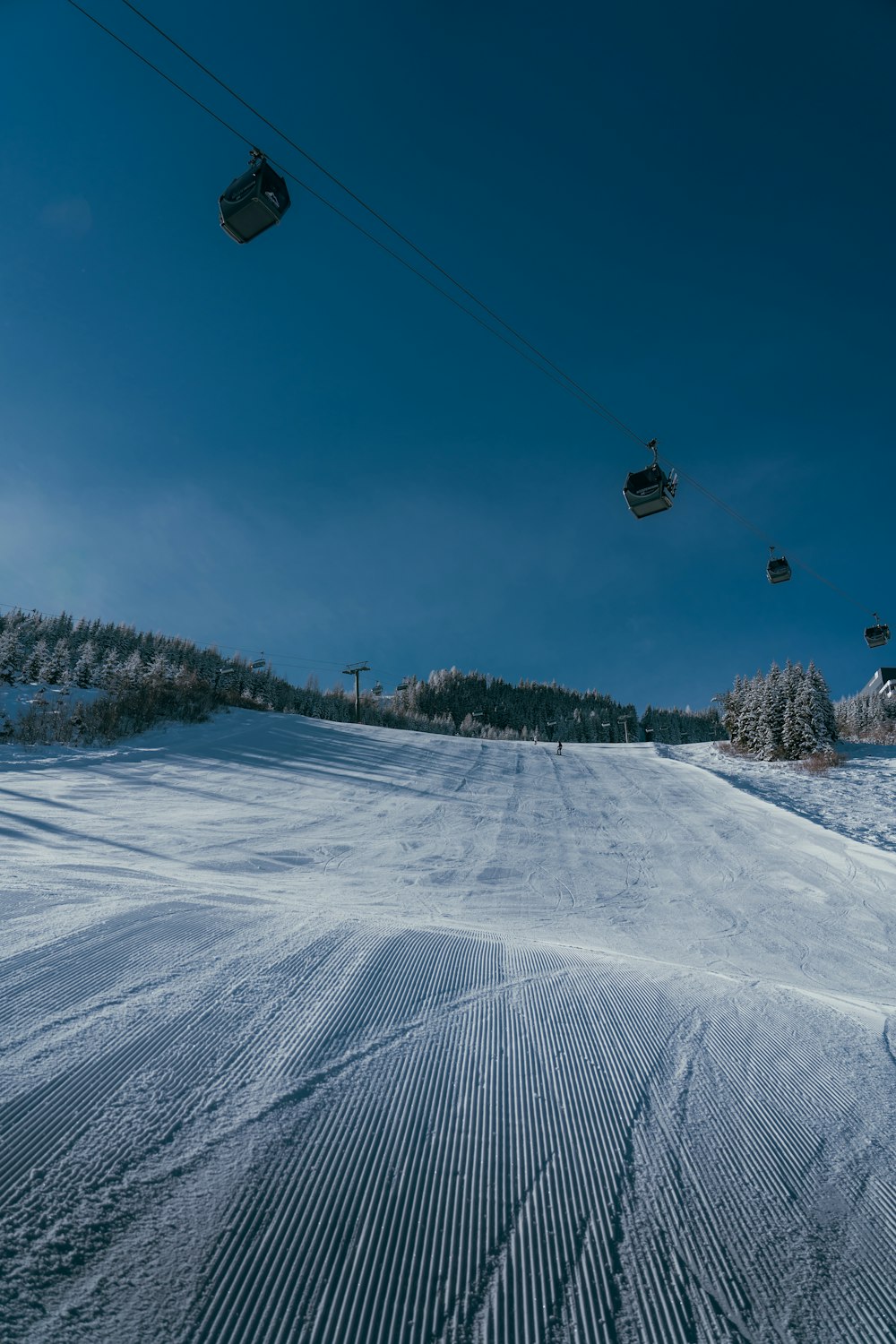 a person riding a snowboard down a snow covered slope