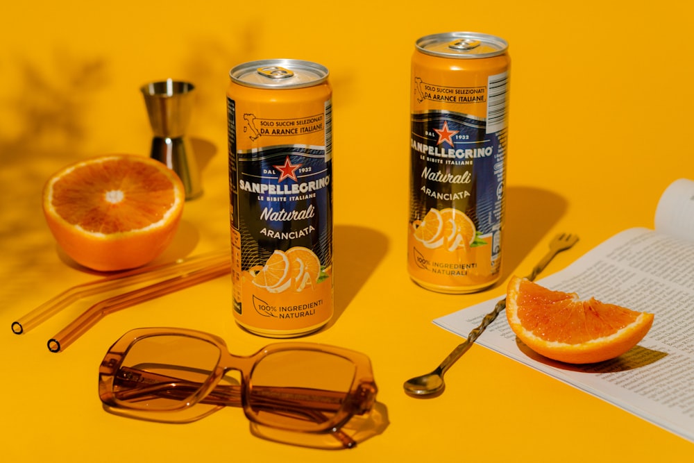 a can of orange juice next to a pair of sunglasses