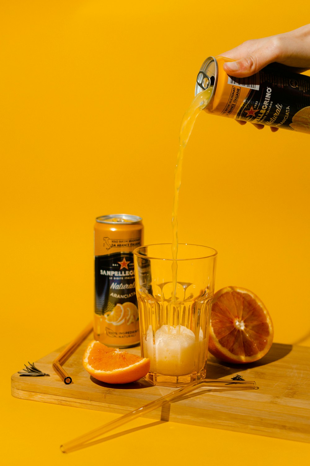 a person pouring orange juice into a glass