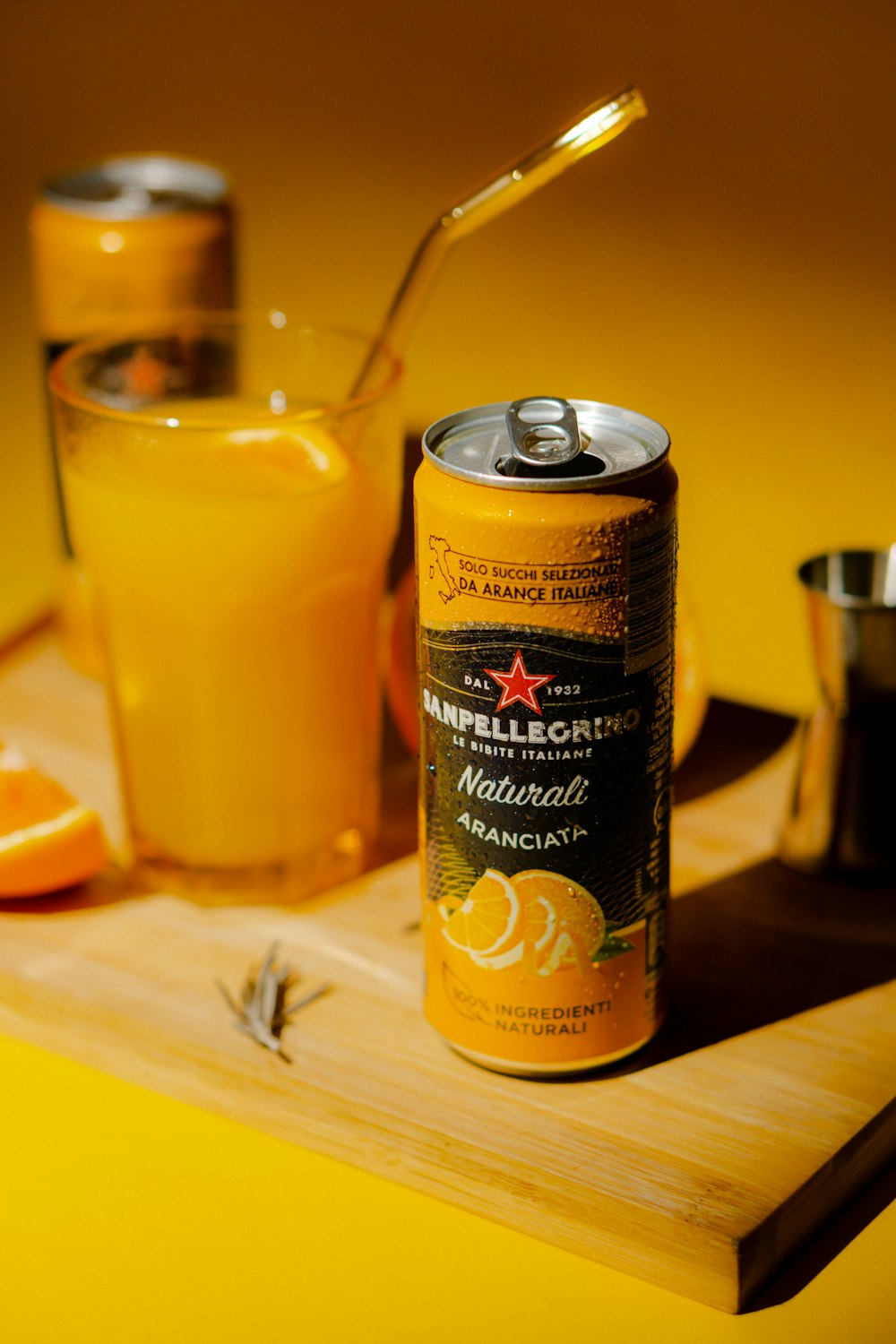 a can of orange juice next to a glass of orange juice